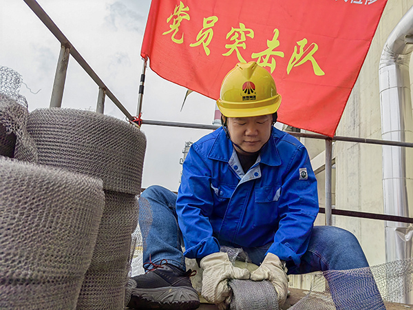 5月10日中午，在動力車間三期工藝除氧器平臺上，黨員突擊隊隊長李鑫正在纏繞新填料.jpg