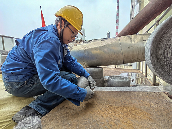 5月10日中午，在動力車間三期工藝除氧器平臺上，黨員突擊隊隊員劉瑞斌正在纏繞新填料.jpg