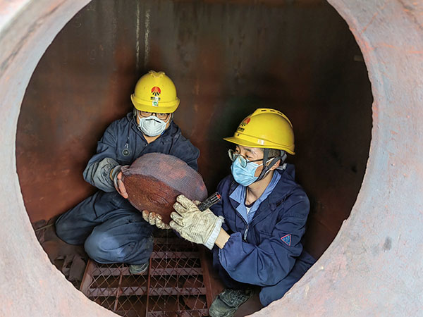 5月11日，動(dòng)力車(chē)間三期工藝除氧器內(nèi)部，黨員突擊隊(duì)隊(duì)員劉瑞斌和李震正在清理舊填料.jpg